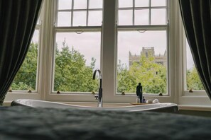 A bathroom with a large window, a sink, and a mirror.