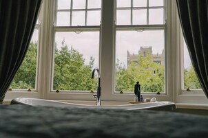 Ein Badezimmer mit großem Fenster, Waschbecken und Spiegel.