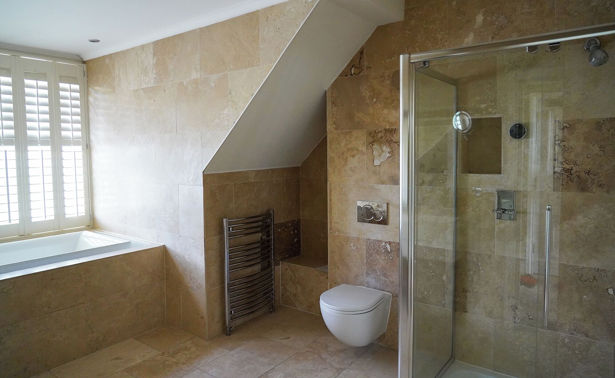 A modern bathroom with a glass shower enclosure, a white toilet, and a towel rack.