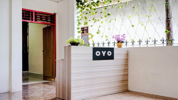 Una recepción con un letrero que dice "OYO" y una planta encima.