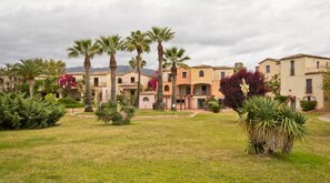 A residential complex with multiple buildings, palm trees, and a well-maintained lawn. - Classical Residence Baia Delle Palme 2 Bedroom Apartment Sleeps 6 Persons T6 (Pula)