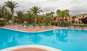A swimming pool with lounge chairs and palm trees. - Classical Residence Baia Delle Palme 2 Bedroom Apartment Sleeps 6 Persons T6 (Pula)