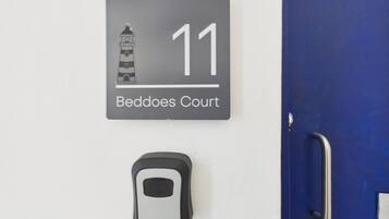 A wall-mounted sign with a lighthouse illustration and the number 11, labeled 'Beddoes Court.'