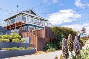 A two-story house with a balcony, a wooden fence, and a garden with purple flowers. - Pacific Paradise steps from the Beach! (Santa Cruz)