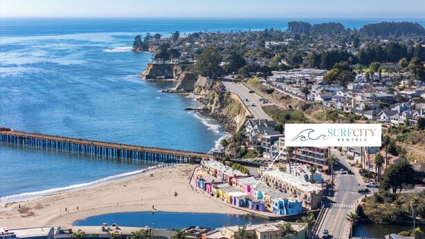 A coastal town with a pier, colorful buildings, and a beach.