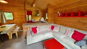 A cozy cabin interior with a dining area, kitchen, and a sofa with pillows. - Cozy Vacation Home, Namur (Viroinval)
