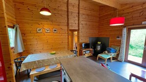 A cozy cabin interior with a wooden interior, a dining area, a washing machine, and a fireplace. - Cozy Vacation Home, Namur (Viroinval)