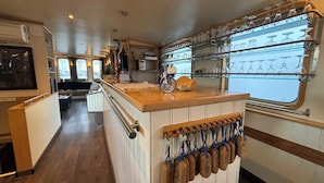 A kitchen with a wooden counter, a bicycle, and a wine rack. - Hotelboat Iris (Amsterdam)