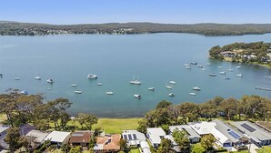 Un lago con numerosos barcos, rodeado de viviendas y vegetación.