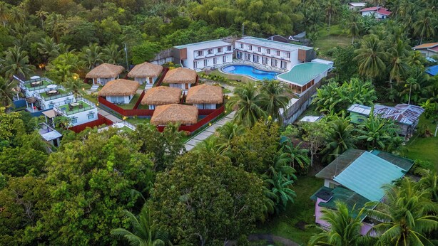 Ein Resort mit mehreren Gebäuden, einem Pool und üppiger Bepflanzung.