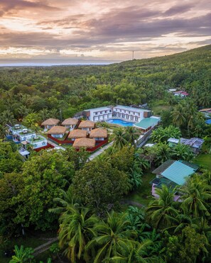 Ein Resort mit mehreren Gebäuden, einem Pool und üppiger Bepflanzung.