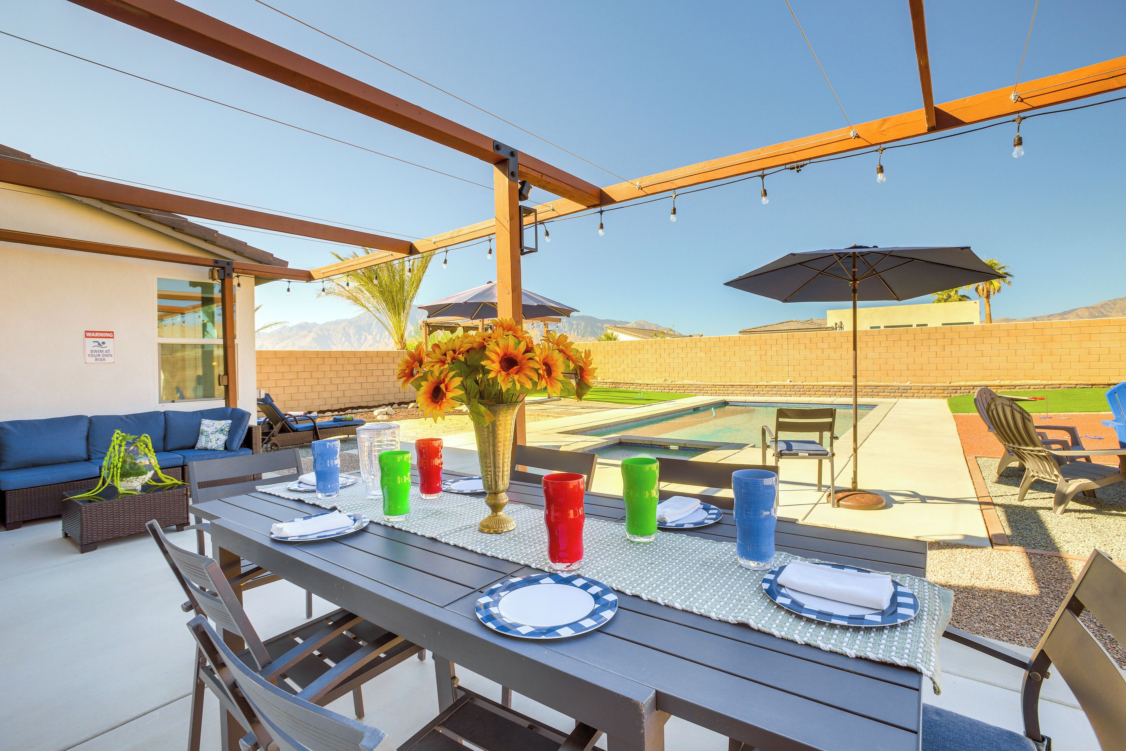 Eine Terrasse im Freien mit Esstisch, Stühlen und einer Sitzecke.