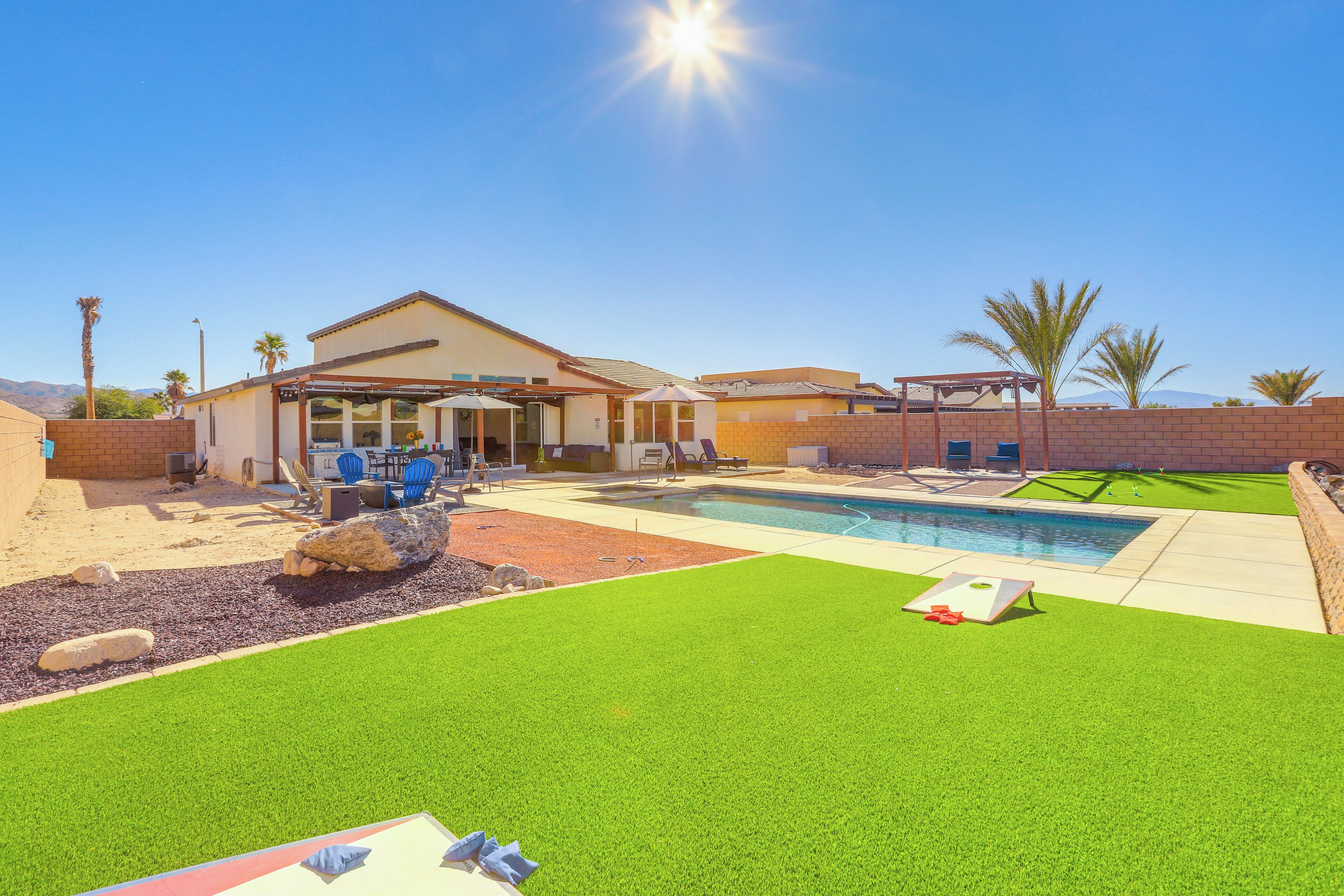 Ein Garten mit Pool, Terrassenmöbeln und einer überdachten Sitzgelegenheit.