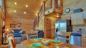 A cozy cabin interior with a dining area, kitchen, and living space.