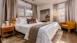 A bedroom with a bed, bedside table, lamp, chair, and a ceiling fan. - Hammock House at Bella Vista (Bella Vista)