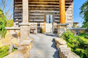 Une cabane en rondins avec un sentier de pierres menant à l’entrée.
