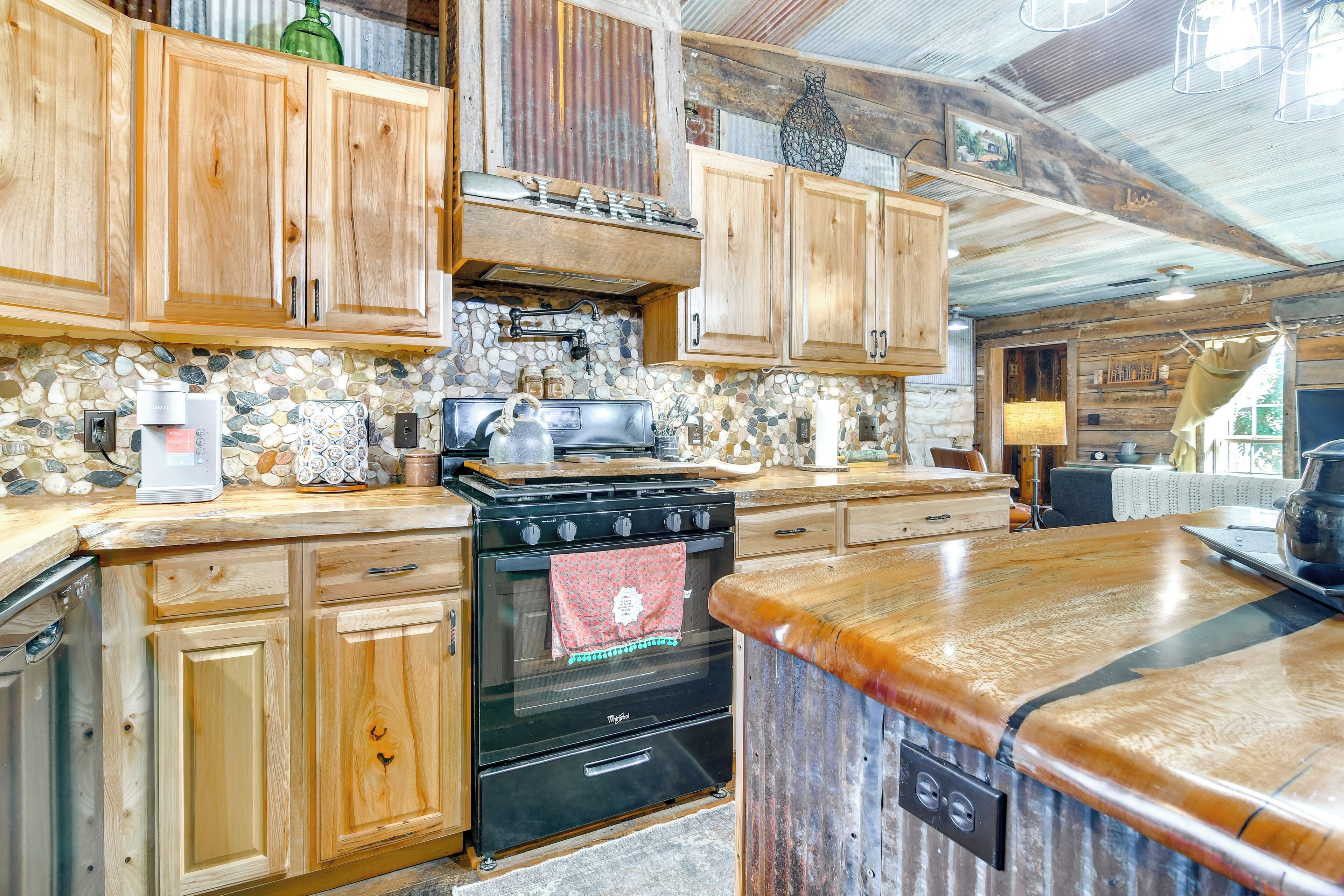 A rustic kitchen with wooden cabinets, a stone backsplash, and a black stove.