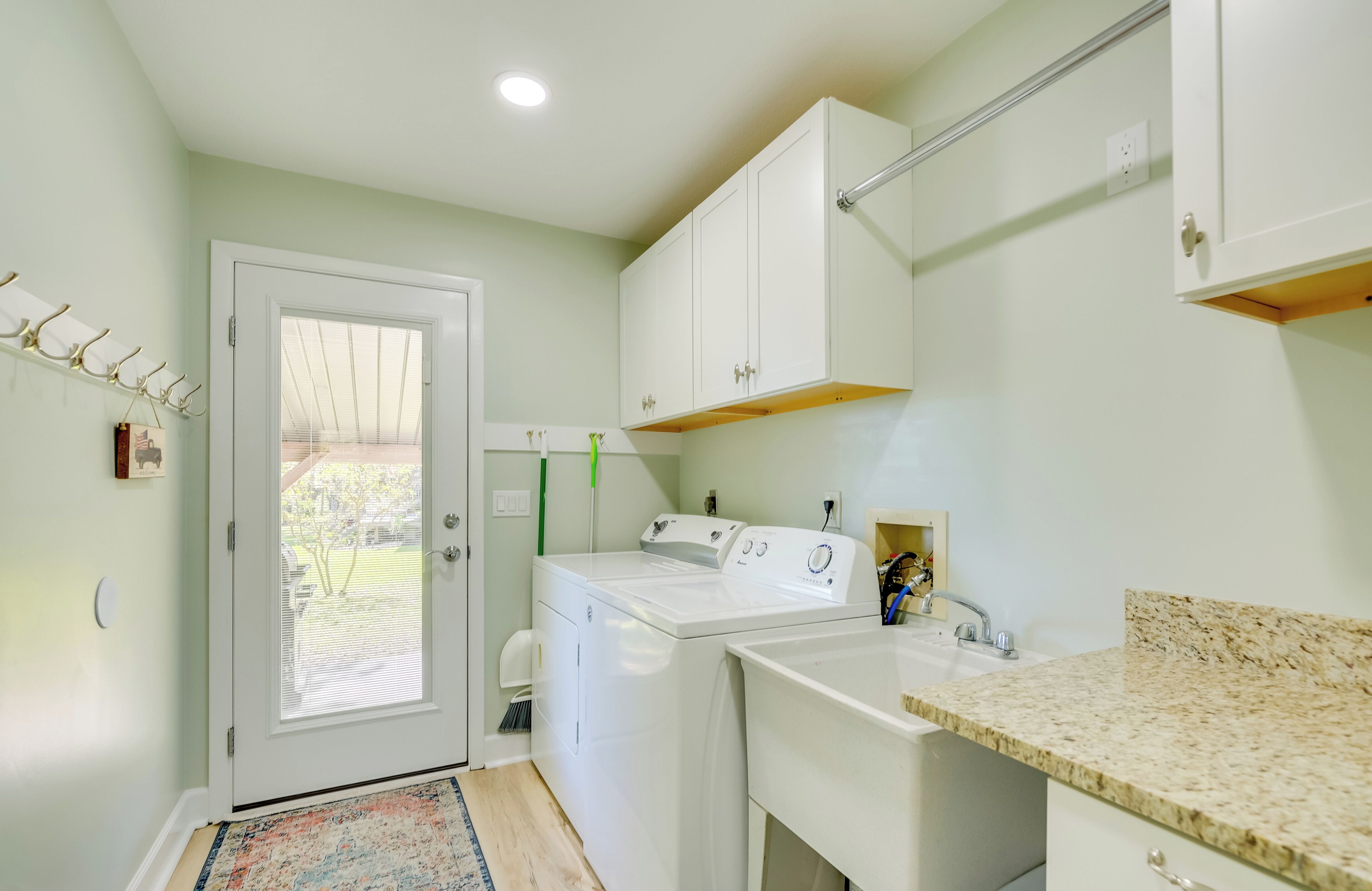 A laundry room with a washing machine, dryer, and sink.