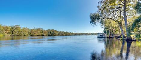 A calm lake with a dock and trees.
