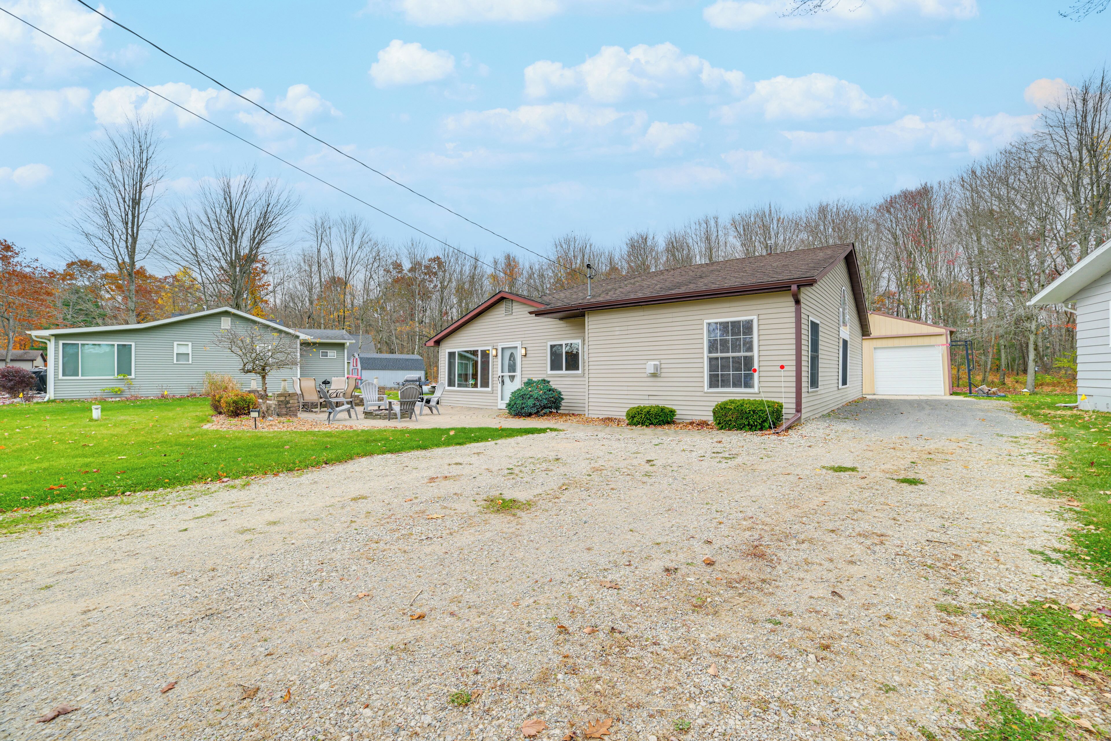 A single-story house with a front porch, a garage, and a small front yard with a gravel driveway.