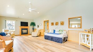 A spacious living room with a fireplace, a bed, and a dining area. - Steps to Long Lake: Cabin w/ Patio in Harrison! (Harrison)