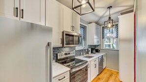 A modern kitchen with white cabinets, stainless steel appliances, and a wooden floor. - Walk to Creek: Mount Joy Home Near Nook Sports (Mount Joy)