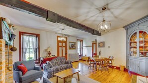 A spacious living area with a fireplace, wooden floors, and a dining area with a table and chairs. - Walk to Creek: Mount Joy Home Near Nook Sports (Mount Joy)