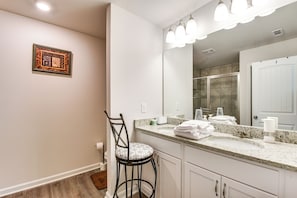 A bathroom with a large mirror, a sink, and a chair. - Work, Explore & Relax: Modern Townhome in Lula! (Lula)