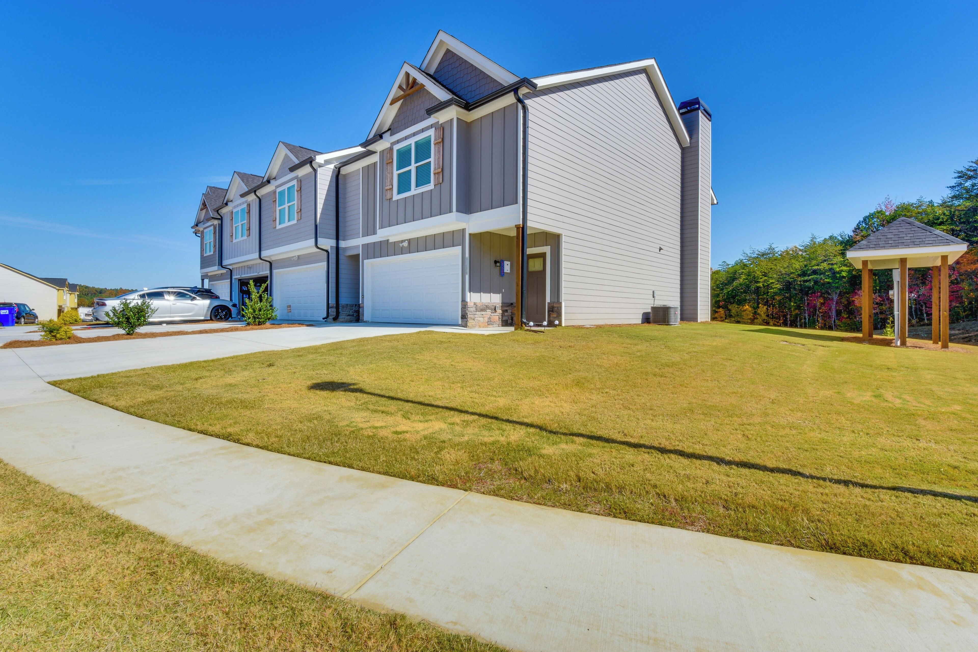 A two-story residential house with a garage, a covered porch, and a well-maintained lawn.