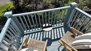 A wooden deck with two wicker chairs and a round table. - Inn at Perkins Cove (Ogunquit)