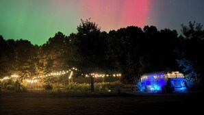 Una casa con una entrada iluminada en azul y una guirnalda de luces en primer plano.