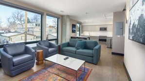 Een moderne woonkamer met een bank, fauteuils en een salontafel.
