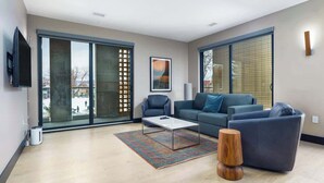 Una sala de estar moderna con un sofá, una mesa de centro y un televisor montado en la pared.