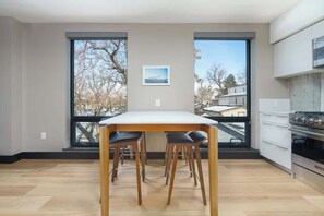Enjoy a meal with a view from this kitchen, featuring a large window and modern appliances.