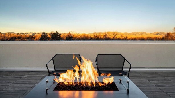 Une terrasse sur le toit, dotée d’un foyer et de deux chaises.