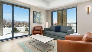 A modern living room with large windows, a sofa, a coffee table, and a chair. - Sleek Tennyson St Flat w/ Balcony & Views (Denver)