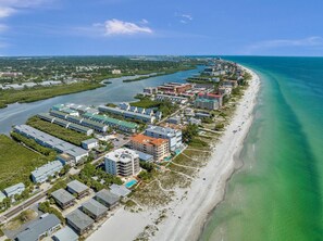 Ein Luftbild eines Küstenresorts mit Strandhäusern, einer Marina und freiem Blick auf den Ozean.