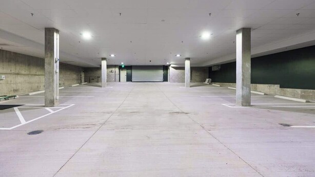 An indoor parking garage with concrete pillars, a flat ceiling, and a central exit. - Stylish Flat on Tennyson - Walk to Dining & Shops! (Denver)