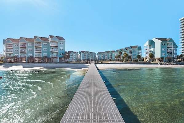 A resort with a clear water walkway leading to a beach, surrounded by multi-story buildings with balconies. - 🏝️Walk to Beach☀️-Sound Front-Baywatch E3 (Pensacola Beach)