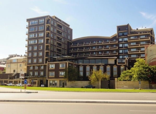 A multi-story building with a curved facade, large windows, and a flat roof.