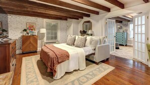 A bedroom with a bed, a dresser, a mirror, and a window. - The Quaint Quarters on Jones, Historic | Quiet (Savannah)