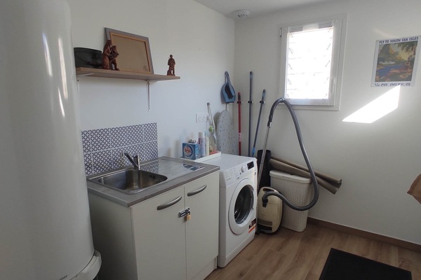 Arrière cuisine avec lave linge et matériel d'entretien