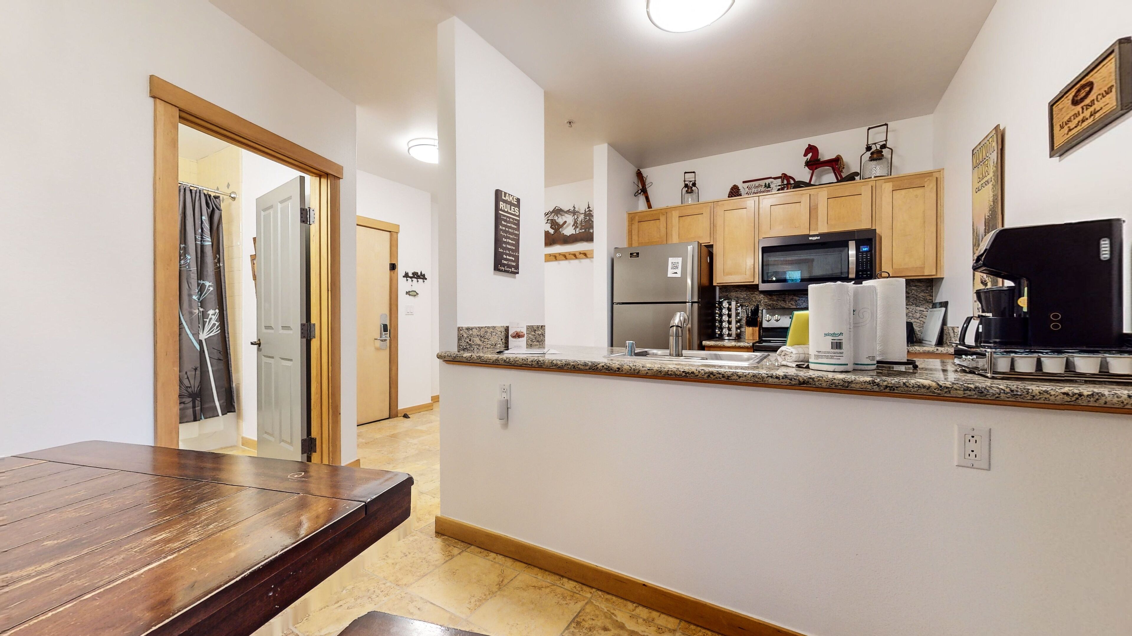 A modern kitchen with granite countertops, stainless steel appliances, and wooden cabinets.