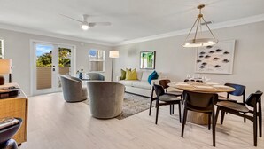 Un salon moderne comprenant un coin repas, un canapé et un ventilateur de plafond.