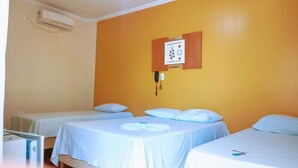 A room with two single beds, a small table, and a wall-mounted phone. - HOTEL ASA BRANCA (Seabra)