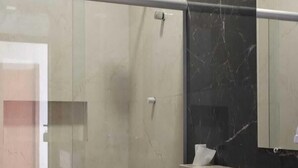 A modern bathroom with a glass-enclosed shower, a toilet, and a marble countertop with a sink. - HOTEL ASA BRANCA (Seabra)