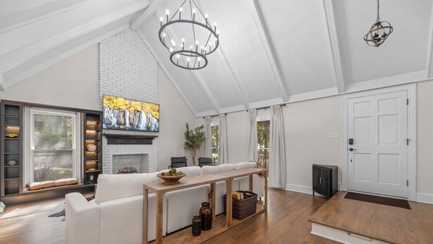 A spacious living room with a white sofa, a wooden coffee table, and a fireplace. - Cozy/Luxe Winter Countryside Estate on Private Grounds in South CLT-King Suite!  (Marvin)