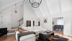 A spacious living room with a white sofa, a coffee table, and a leather rug. - Cozy/Luxe Winter Countryside Estate on Private Grounds in South CLT-King Suite!  (Marvin)