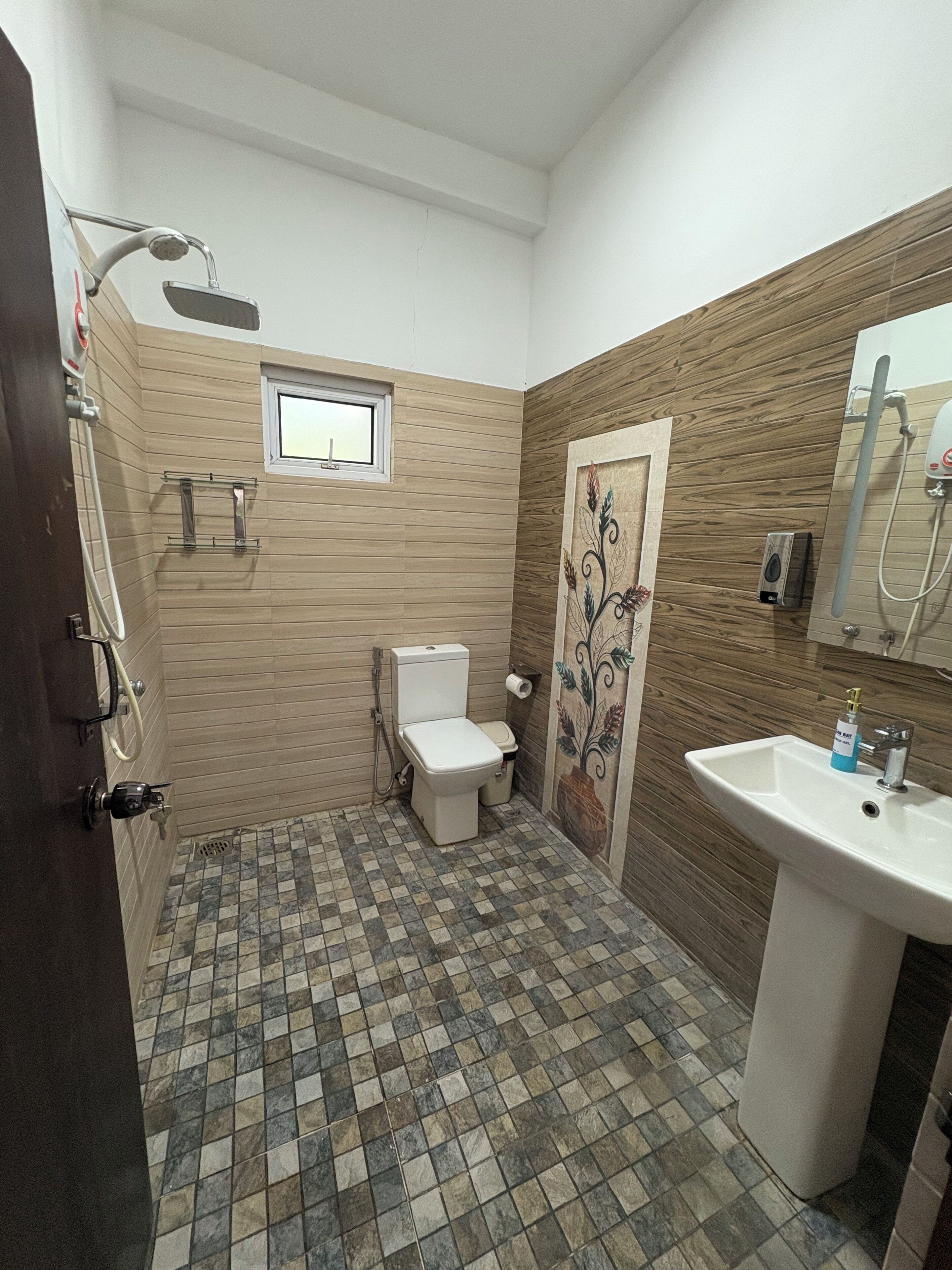 A bathroom with a toilet, shower, and sink.
