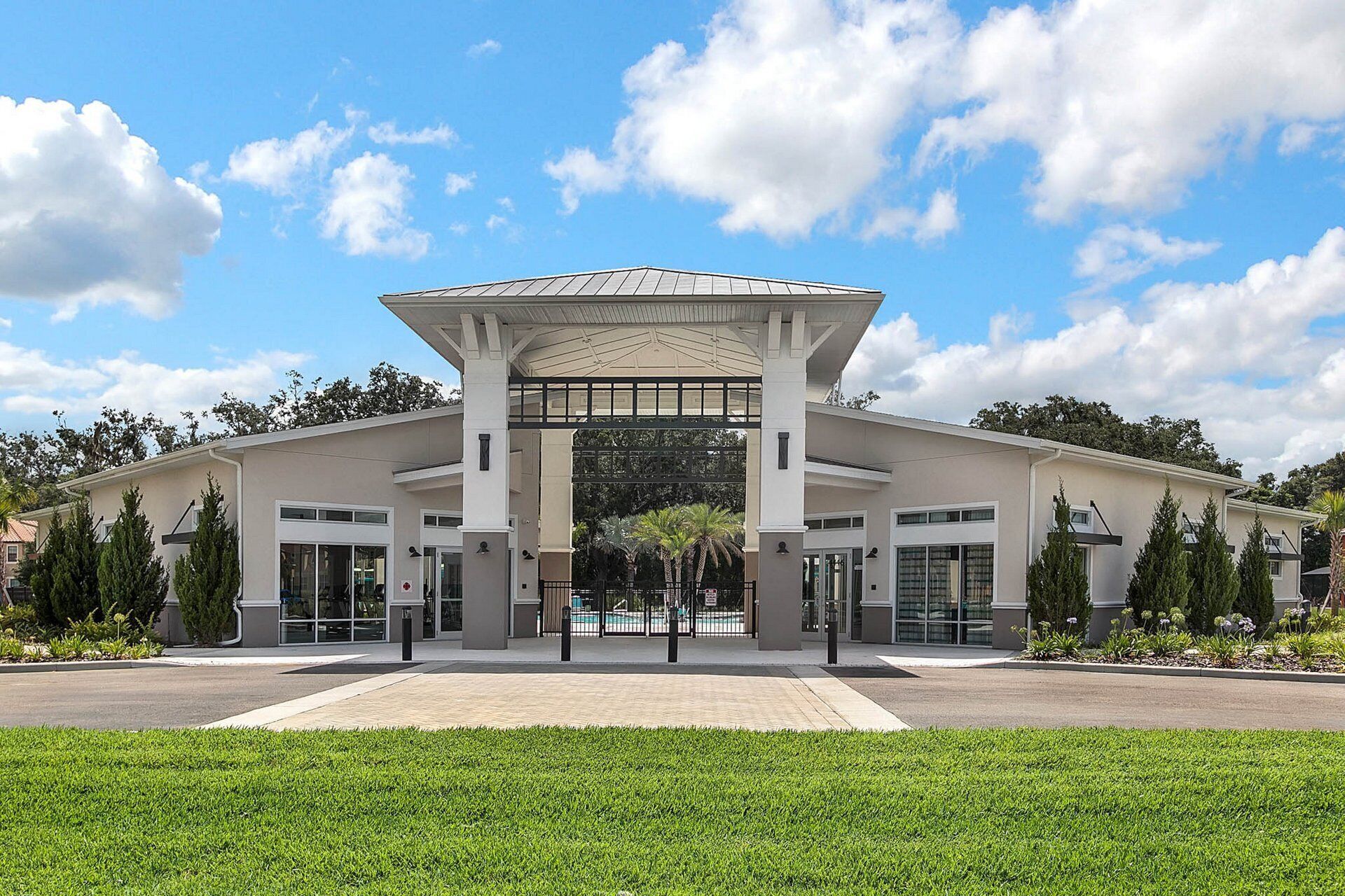 A modern building with a central entrance, large windows, and a covered walkway.